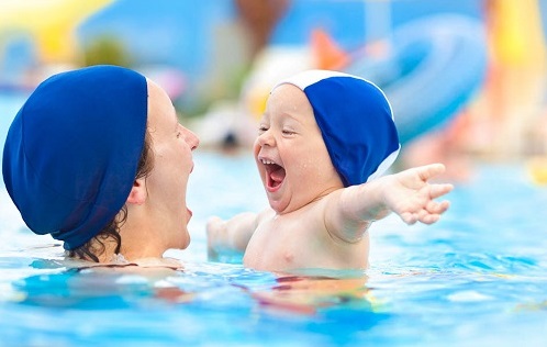 happy child mom swimming pool cap fun hug at sea